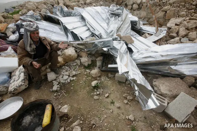 Palestinians sits next to her belongings following the demolition of her home aftar Israeli army bulldozer destroys a Palestinian home, in the village of Khirbet Tana near the West Bank city of Nablus, in the so-called A...