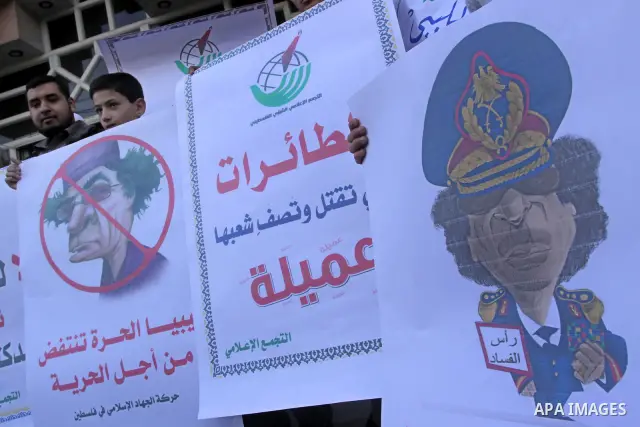 Palestinians hold up placards during a protest against Libyan leader Moamer Kadhafi in Gaza City on February 22, 2011. Gaza's Jihad Islamic rulers heaped condemnation on "the massacres" of anti-government protestors in L...