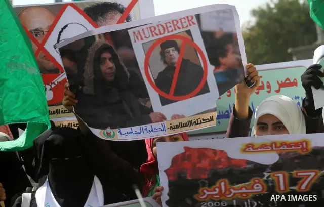 Palestinian students hold up placards during a protest against Libyan leader Moamer Kadhafi, in Gaza City on February 22, 2011. Gaza's Hamas rulers heaped condemnation on "the massacres" of anti-government protestors in...