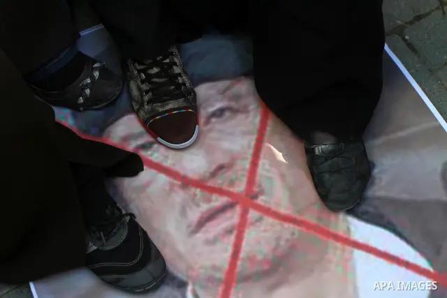 Palestinians step on a poster of Libyan leader Moammar Gadhafi during a march in solidarity with Libya in Gaza City, Tuesday, Feb. 22 , 2011. Gadhafi's 42-year rule is under unprecedented pressure from an uprising that i...