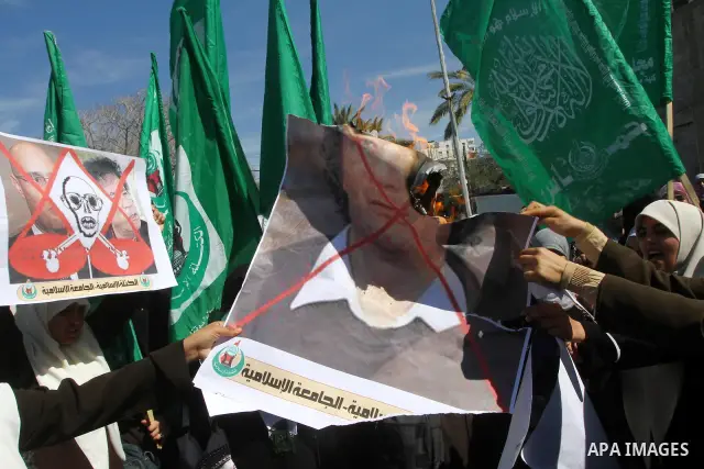 Palestinian students burn a poster of Libyan leader Moammar Gadhafi during a march in solidarity with Libya, in Gaza City, Tuesday, Feb. 22 , 2011. Gadhafi's 42-year rule is under unprecedented pressure from an uprising...