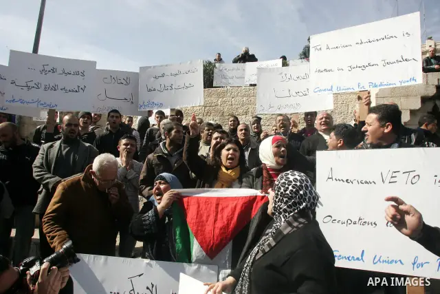 Palestinians take part in a demonstration against the United States' recent veto in the UN Security Council dealing with Israeli settlements in the West Bank, as they protest at the Damascus Gate in East Jerusalem on 22...