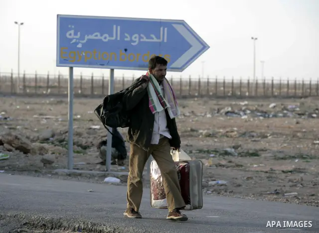 An Egyptian man, who has fled from Libya through the Salloum land port gate walks with has luggage,Tuesday, Feb. 22, 2011. An estimated 5,000 Egyptians have returned home from Libya by land, and about 10,000 more are wai...