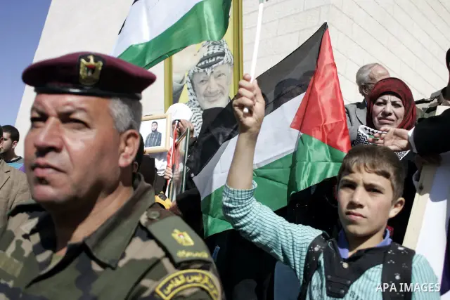 Palestinian protesters hold national flags and banners during a rally against the U.S. veto and calling for the national reconciliation in the West Bank city of Bethlehem, on Feb. 23, 2011. Photo by Najeh Hashlamoun