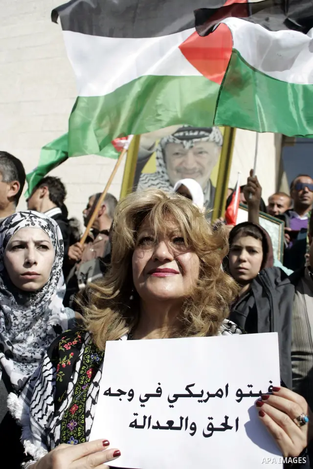 Palestinian protesters hold national flags and banners during a rally against the U.S. veto and calling for the national reconciliation in the West Bank city of Bethlehem, on Feb. 23, 2011. Photo by Najeh Hashlamoun