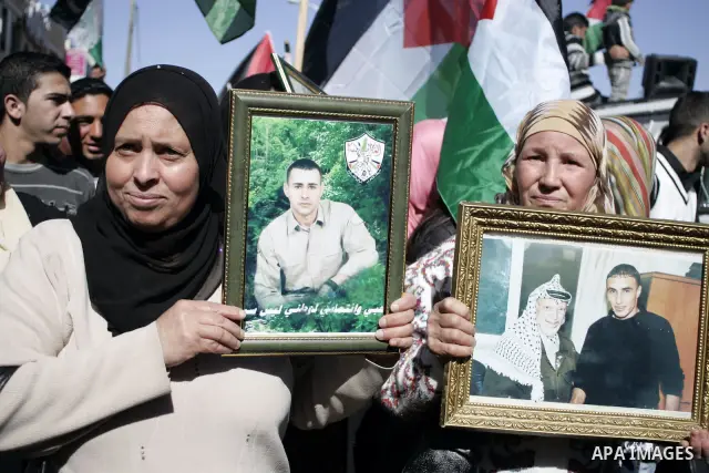 Palestinian protesters hold national flags and banners during a rally against the U.S. veto and calling for the national reconciliation in the West Bank city of Bethlehem, on Feb. 23, 2011. Photo by Najeh Hashlamoun