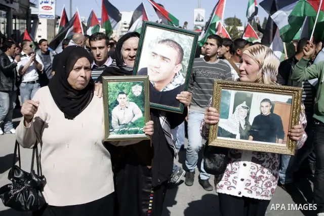 Palestinian protesters hold national flags and banners during a rally against the U.S. veto and calling for the national reconciliation in the West Bank city of Bethlehem, on Feb. 23, 2011. Photo by Najeh Hashlamoun