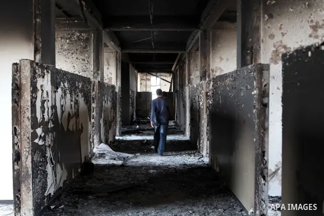 A man walks inside a burned police station in the eastern Libyan town of Derna on Feb. 23, 2011. Unrest shook Libya in recent days as government crackdowns on protesters have resulted in mass casualties, according to hum...
