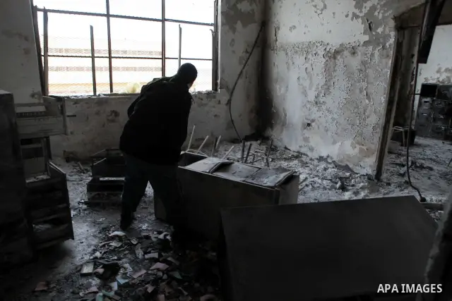 A man walks inside a burned police station in the eastern Libyan town of Derna on Feb. 23, 2011. Unrest shook Libya in recent days as government crackdowns on protesters have resulted in mass casualties, according to hum...