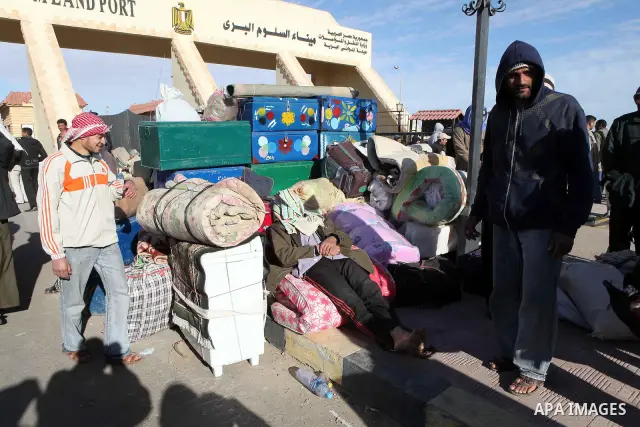 Egyptians, who have fled from Libya through the Salloum land port gate wait with their luggage,Wednesday, Feb. 23, 2011. An estimated 5,000 Egyptians have returned home from Libya by land, and about 10,000 more are waiti...