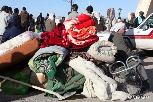 Egyptians, who have fled from Libya through the Salloum land port gate wait with their luggage,Wednesday, Feb. 23, 2011. An estimated 5,000 Egyptians have returned home from Libya by land, and about 10,000 more are waiti...