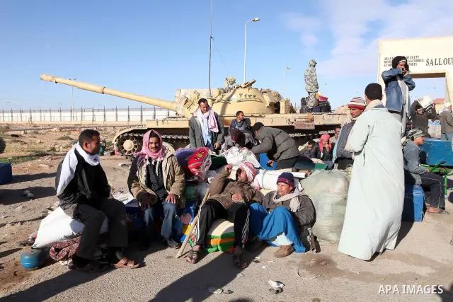 Egyptians, who have fled from Libya through the Salloum land port gate wait with their luggage,Wednesday, Feb. 23, 2011. An estimated 5,000 Egyptians have returned home from Libya by land, and about 10,000 more are waiti...