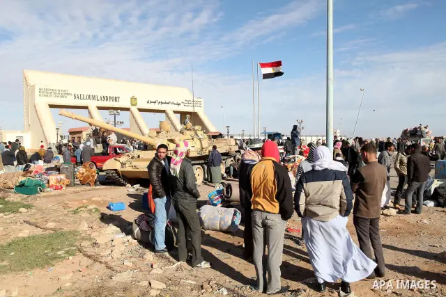 Egyptians, who have fled from Libya through the Salloum land port gate wait with their luggage,Wednesday, Feb. 23, 2011. An estimated 5,000 Egyptians have returned home from Libya by land, and about 10,000 more are waiti...