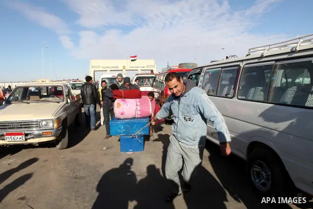 Egyptians, who have fled from Libya through the Salloum land port gate wait with their luggage,Wednesday, Feb. 23, 2011. An estimated 5,000 Egyptians have returned home from Libya by land, and about 10,000 more are waiti...