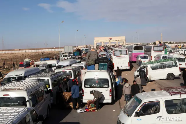 Egyptians, who have fled from Libya through the Salloum land port gate wait with their luggage,Wednesday, Feb. 23, 2011. An estimated 5,000 Egyptians have returned home from Libya by land, and about 10,000 more are waiti...