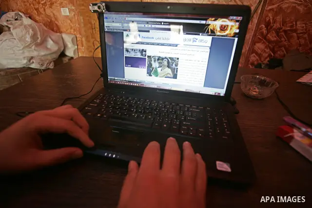 A Palestinian man looks at the computer to follow the hot events in Libya, in Rafah, southern Gaza Strip on February 24, 2011. Palestinian sources confirmed Thursday morning that the Libyan leader Muammar Gaddafi has thr...