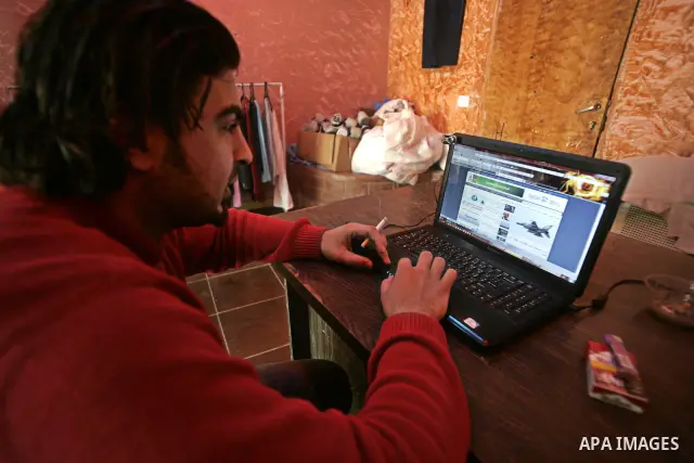A Palestinian man looks at the computer to follow the hot events in Libya, in Rafah, southern Gaza Strip on February 24, 2011. Palestinian sources confirmed Thursday morning that the Libyan leader Muammar Gaddafi has thr...