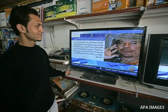 A Palestinian man looks on the television to watch the hot events in Libya, in Rafah, southern Gaza Strip on February 24, 2011. Palestinian sources confirmed Thursday morning that the Libyan leader Muammar Gaddafi has th...