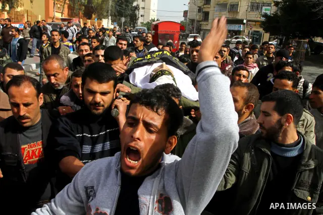 Palestinian mourners carry the body of Islamic Jihad militant Adel Jundia during his funeral in Gaza City on February 24, 2011, a day after he was killed by Israeli tank fire during clashes east of Gaza City. Ten other P...