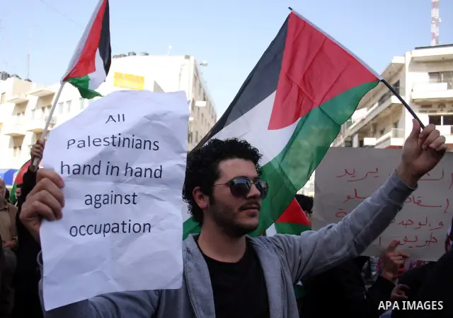 A Palestinian man takes part in a rally calling for ending the Palestinian division, in the West Bank city of Ramallah on Feb. 24, 2011. More than 3000 protesters call for free elections and the reconciliation between th...