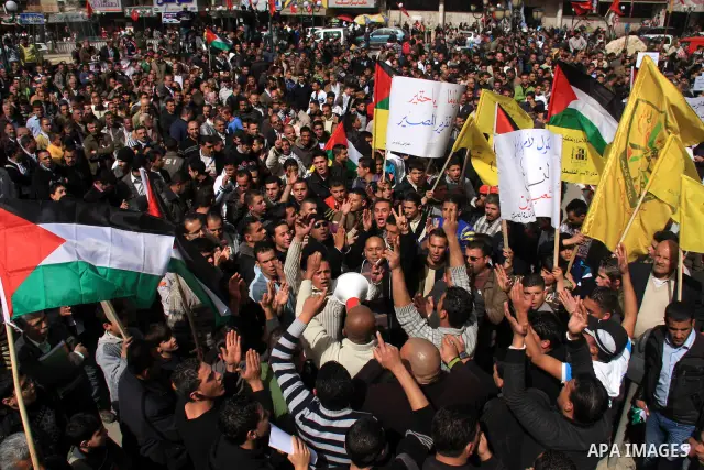 Palestinian protesters hold national flags and banners during a rally against the U.S. veto and calling for the national reconciliation in the West Bank city of Nablus, Thursday, Feb. 24, 2011. Photo by Wagdi Eshtayah