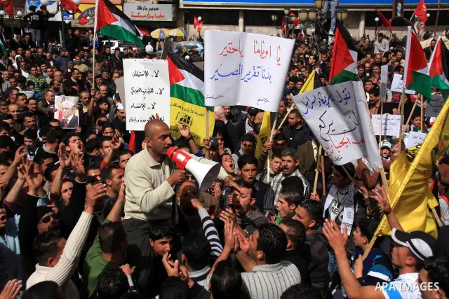 Palestinian protesters hold national flags and banners during a rally against the U.S. veto and calling for the national reconciliation in the West Bank city of Nablus, Thursday, Feb. 24, 2011. Photo by Wagdi Eshtayah