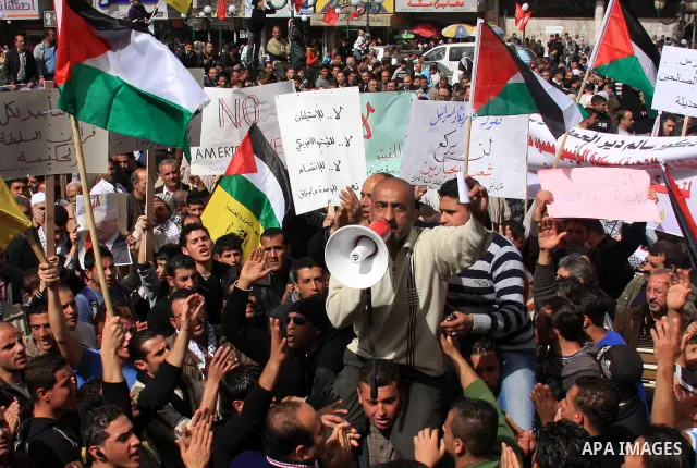 Palestinian protesters hold national flags and banners during a rally against the U.S. veto and calling for the national reconciliation in the West Bank city of Nablus, Thursday, Feb. 24, 2011. Photo by Wagdi Eshtayah