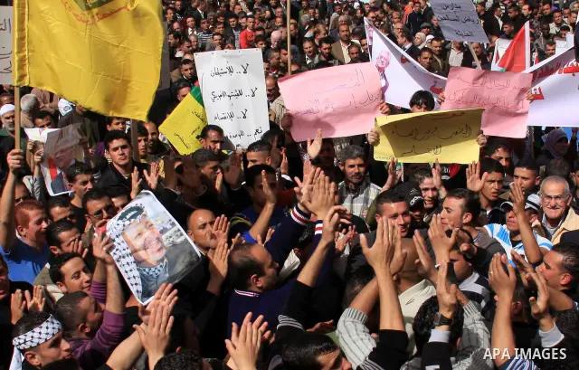 Palestinian protesters hold national flags and banners during a rally against the U.S. veto and calling for the national reconciliation in the West Bank city of Nablus, Thursday, Feb. 24, 2011. Photo by Wagdi Eshtayah