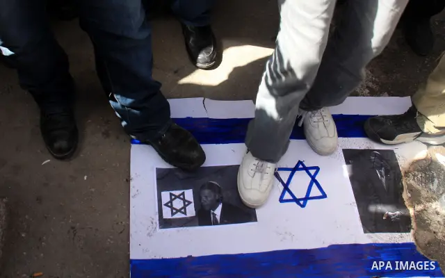 Palestinian protesters step on a poster of president Barack Obama ,during a rally against the U.S. veto and calling for the national reconciliation in the West Bank city of Nablus, Thursday, Feb. 24, 2011. Photo by Wagdi...