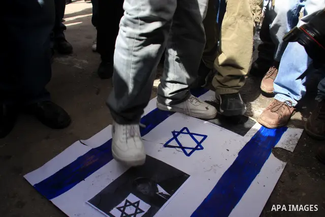 Palestinian protesters step on a poster of the Israel flag and president Barack Obama ,during a rally against the U.S. veto and calling for the national reconciliation in the West Bank city of Nablus, Thursday, Feb. 24,...