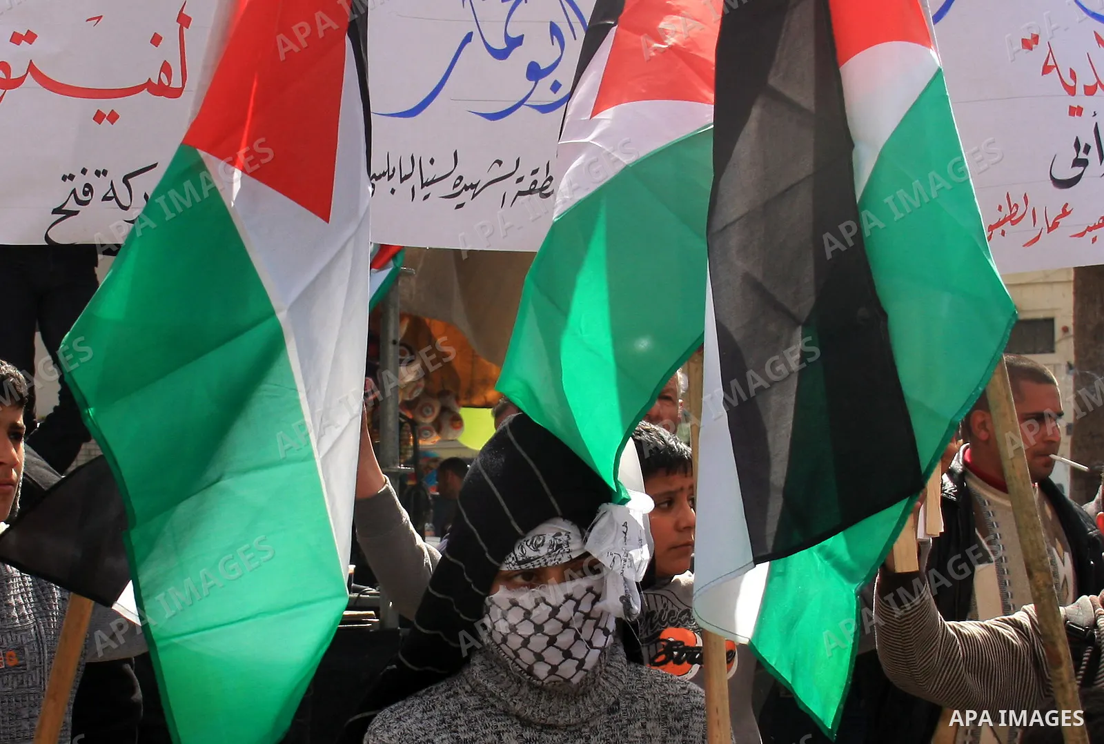 Palestinian protesters hold national flags and banners during a rally against the U.S. veto and calling for the national reconciliation in the West Bank city of Nablus, Thursday, Feb. 24, 2011. Photo by Wagdi Eshtayah