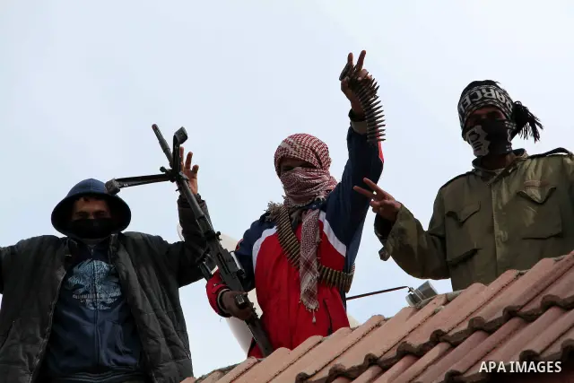 A Libyan gunman as he holds his automatic machine gun , in Albedia , Libya, on Thursday Feb. 24, 2011. A Libyan witness says a Libyan army unit has blasted a minaret of a mosque in a city west of Tripoli. The witness tel...