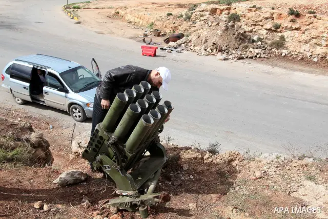 A Libyan gunman as he holds his automatic machine gun , in Albedia , Libya, on Thursday Feb. 24, 2011. A Libyan witness says a Libyan army unit has blasted a minaret of a mosque in a city west of Tripoli. The witness tel...