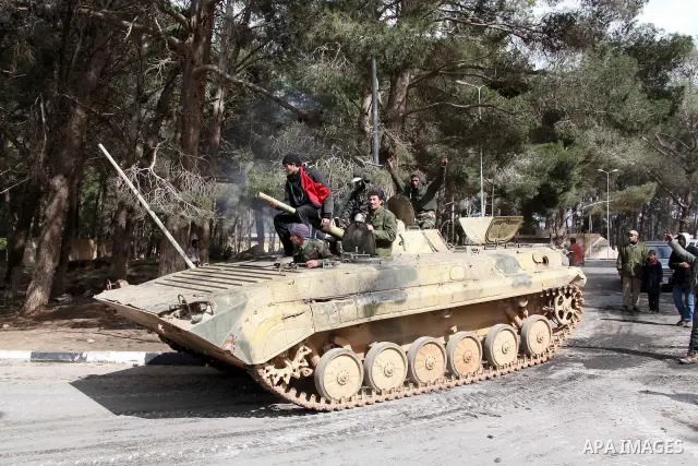 Anti-government protesters make victory signs as they stand on an army tank near a square where people are protesting in ALbedi city, Libya, February 24, 2011. Thousands of Libyans celebrated the liberation of the easter...