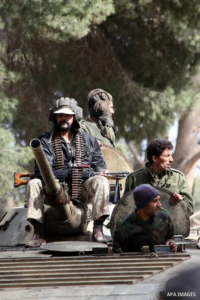 A Libyan gunman as he holds his automatic machine gun , in Albedia , Libya, on Thursday Feb. 24, 2011. A Libyan witness says a Libyan army unit has blasted a minaret of a mosque in a city west of Tripoli. The witness tel...