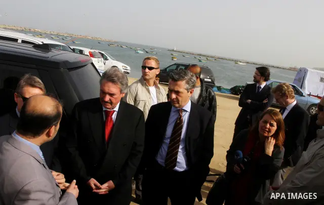 Luxembourg's Foreign Minister Jean Asselborn, centre, listens to explanation from UNRWA official upon his arrival to the Gaza fishermen port in Gaza City, Friday, Feb. 25, 2011. Asselborn is on an official visit to Gaza....