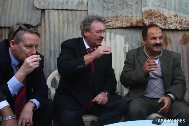Luxembourg's Foreign Minister Jean Asselborn, drinks an Arabic coffee while he meets Palestinian fishermen during his tour to the Gaza fishermen port in Gaza City, Friday, Feb. 25, 2011. Asselborn is on an official visit...