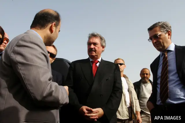 Luxembourg's Foreign Minister Jean Asselborn, centre, listens to explanation from UNRWA official upon his arrival to the Gaza fishermen port in Gaza City, Friday, Feb. 25, 2011. Asselborn is on an official visit to Gaza....