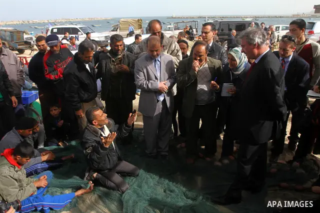 Luxembourg's Foreign Minister Jean Asselborn, centre, listens to explanation from UNRWA official upon his arrival to the Gaza fishermen port in Gaza City, Friday, Feb. 25, 2011. Asselborn is on an official visit to Gaza....
