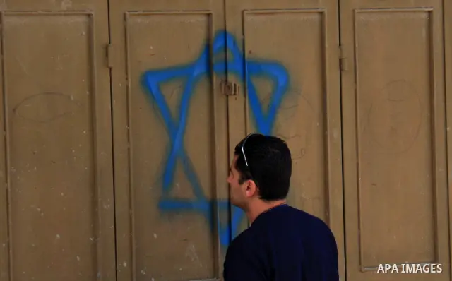 An Israeli next to the Star of david in the village of Jeet the West bank city of Qalqilya, Friday,25, 2011. Palestinians and the Israeli military said Friday Jewish settlers vandalized in a Palestinian village in the We...