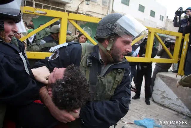 Israeli police officers try to push back Palestinian, Israeli and foreign activists during a protest against the continued closure of Shuhada street to Palestinians, in the West Bank city of Hebron 25 February 2011. The...