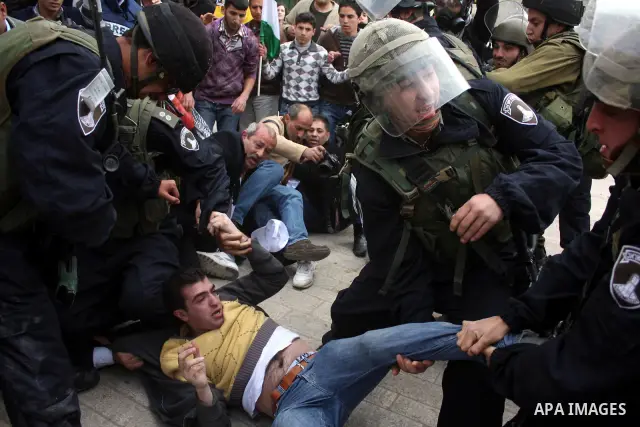 Israeli police officers try to push back Palestinian, Israeli and foreign activists during a protest against the continued closure of Shuhada street to Palestinians, in the West Bank city of Hebron 25 February 2011. The...