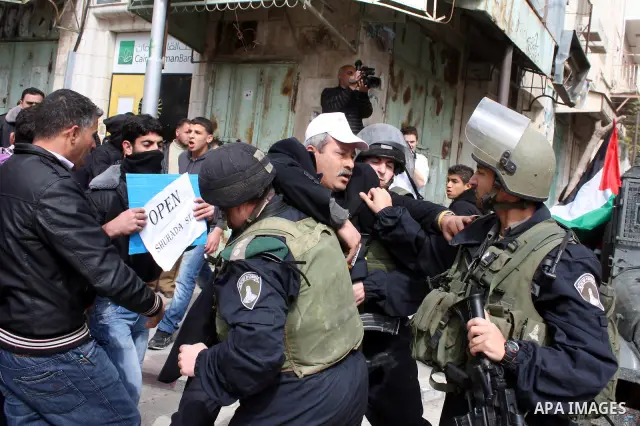 Israeli police officers try to push back Palestinian, Israeli and foreign activists during a protest against the continued closure of Shuhada street to Palestinians, in the West Bank city of Hebron 25 February 2011. The...