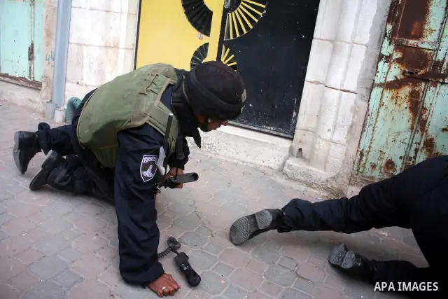Israeli police officer falls on the ground during a protest against the continued closure of Shuhada street to Palestinians, in the West Bank city of Hebron 25 February 2011. The activists gathered on Friday calling for...