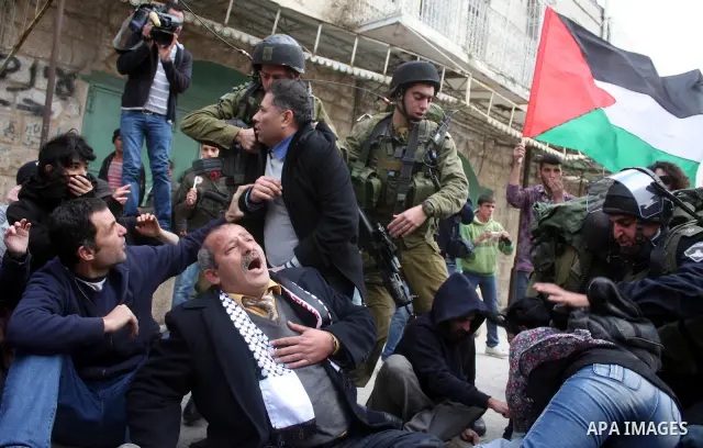 Israeli police officers try to push back Palestinian, Israeli and foreign activists during a protest against the continued closure of Shuhada street to Palestinians, in the West Bank city of Hebron 25 February 2011. The...