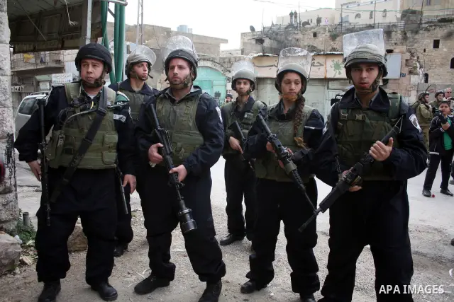 Israeli police officer fires tear gas canisters towards Palestinian, Israeli and foreign activists during a protest against the continued closure of Shuhada street to Palestinians, in the West Bank city of Hebron 25 Febr...
