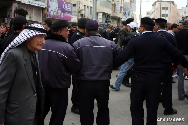 Palestinian riot-police take positions to prevent clashes between Palestinian protesters and Israeli security forces, not pictured, during a demonstration against the closure of Shuhada street to Palestinians, in the Wes...