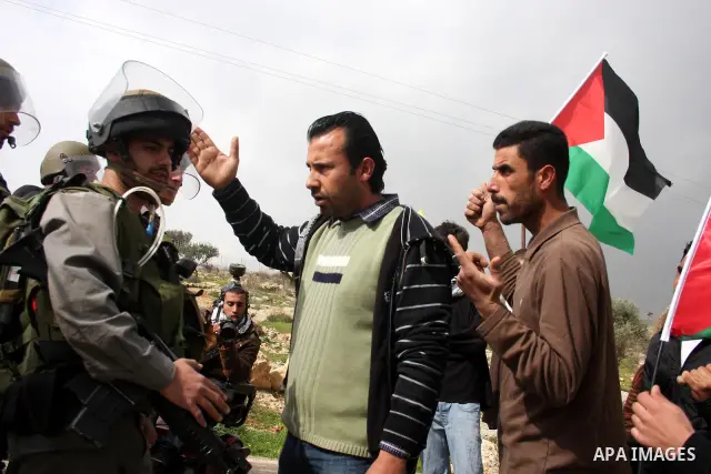 Israeli soldiers take position during a Palestinian protest against the controversial Israeli barrier in the West Bank village of Bilin near Ramallah, Feb. 25, 2011. Photo by Issam Rimawi
