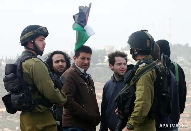 Protesters argue with an Israeli soldier during a demonstration against Israel's controversial separation barrier in the West Bank village of Maasarah, near the biblical town of Bethlehem on 25 February 2011.Israel says...