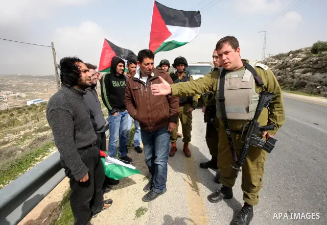 Protesters argue with an Israeli soldier during a demonstration against Israel's controversial separation barrier in the West Bank village of Maasarah, near the biblical town of Bethlehem on 25 February 2011.Israel says...